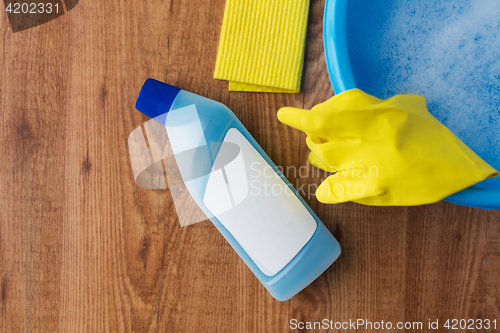 Image of basin with cleaning stuff on wooden background