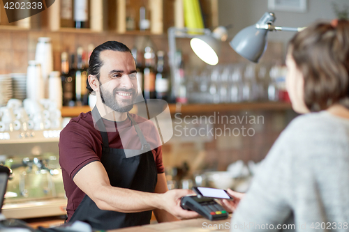 Image of barman and woman with card reader and smartphone