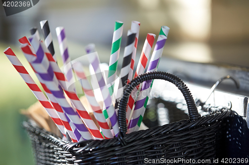 Image of disposable straws in whickered basket outdoors