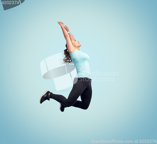 Image of happy smiling sporty young woman jumping in air