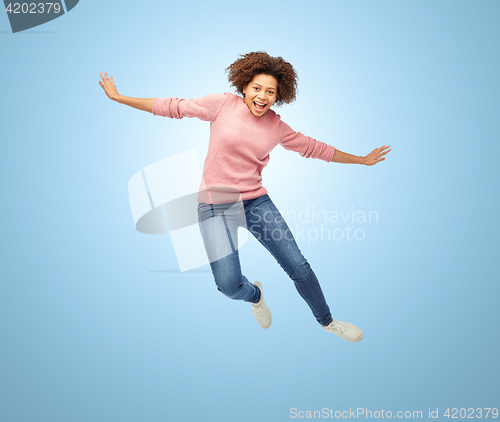 Image of happy african american woman jumping over white