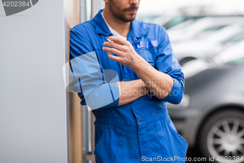 Image of close up of auto mechanic smoking cigarette