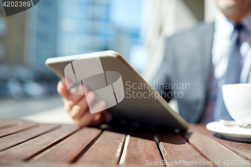 Image of businessman with tablet pc and coffee outdoors