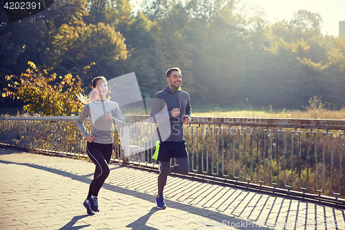 Image of happy couple running outdoors