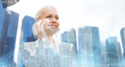 Image of happy businesswoman calling on smartphone in city