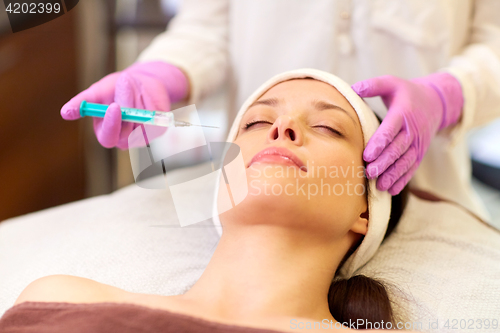 Image of beautician doing beauty injection to woman lips