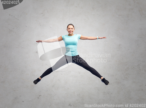 Image of happy smiling sporty young woman jumping in air