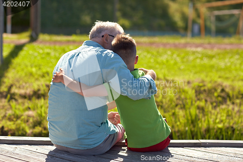 Image of grandfather and grandson hugging on berth