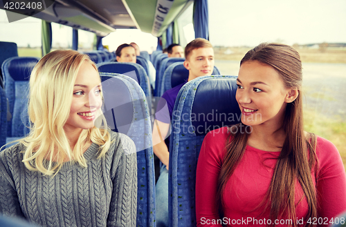 Image of happy young women talking in travel bus