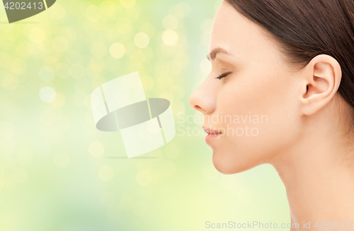 Image of beautiful young woman face over green background