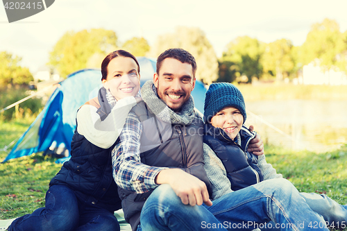 Image of happy family with tent at camp site