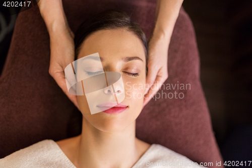 Image of woman having face and head massage at spa