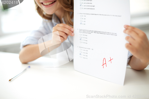 Image of happy girl with test paper at school