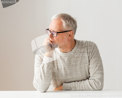 Image of close up of senior man in glasses thinking