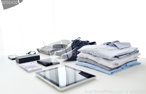 Image of clothes, gadgets and business stuff on table