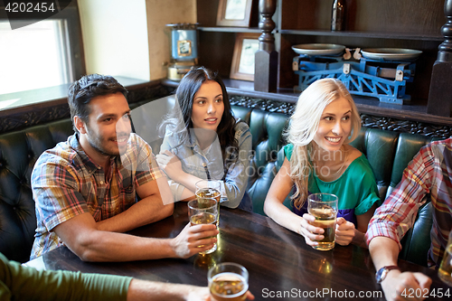 Image of friends with beer watching football at bar or pub