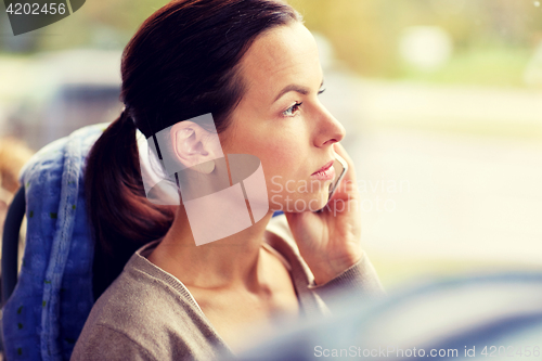 Image of woman in travel bus calling on smartphone