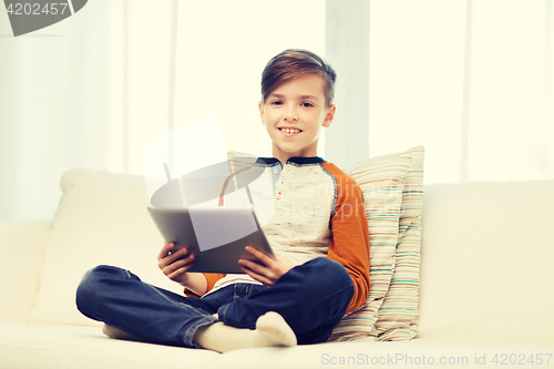 Image of smiling boy with tablet computer at home