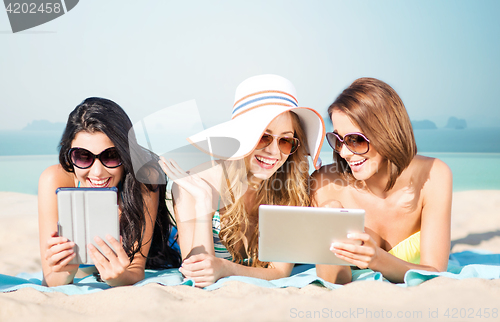 Image of happy young women with tablet pc on summer beach