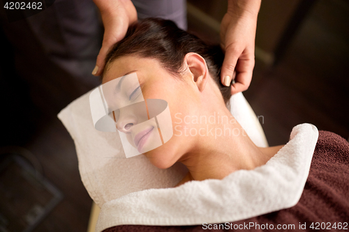 Image of woman having head massage at spa