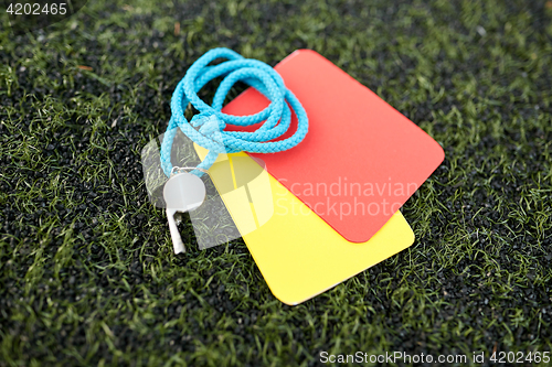 Image of whistle and caution cards on football field