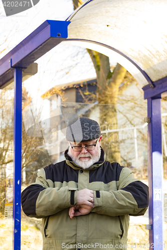 Image of Male senior looks at his watch