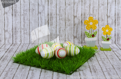 Image of Colorful easter eggs with decorative wooden flowers 