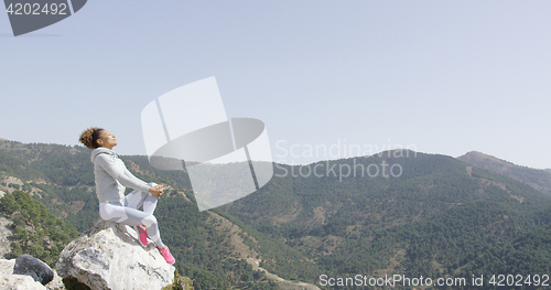 Image of Happy sportive woman on rock