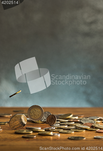 Image of The silver and golden coins and falling coins on wooden background