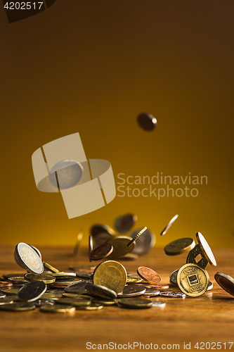 Image of The silver and golden coins and falling coins on wooden background