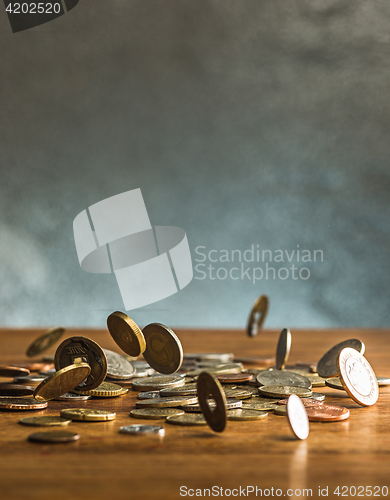 Image of The silver and golden coins and falling coins on wooden background