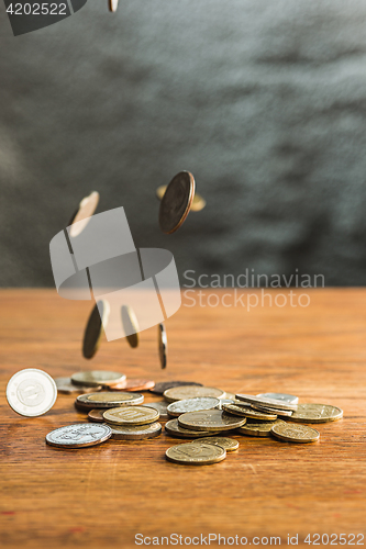 Image of The silver and golden coins and falling coins on wooden background