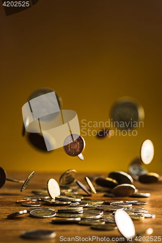 Image of The silver and golden coins and falling coins on wooden background