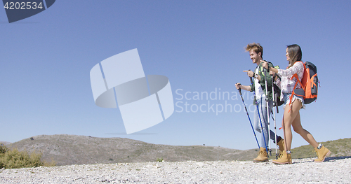 Image of Funny couple walking with trekking poles