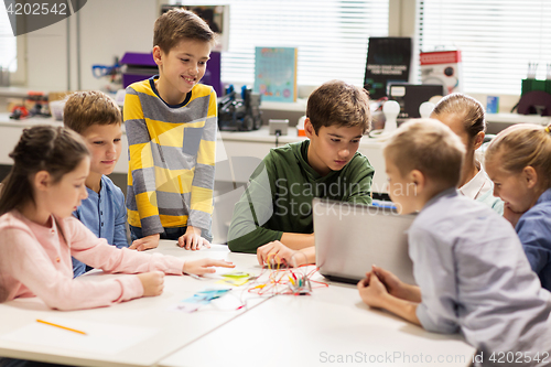 Image of happy children with laptop at robotics school