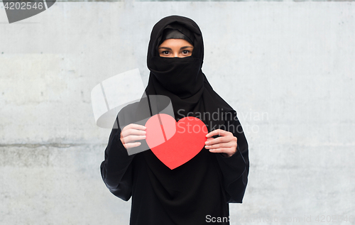 Image of muslim woman in hijab holding red heart