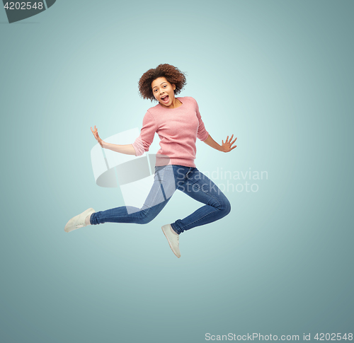 Image of happy african american woman jumping over white