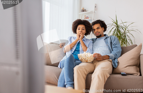 Image of couple with popcorn watching tv at home