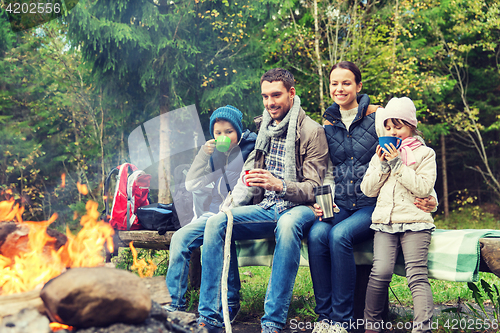 Image of happy family sitting on bench at camp fire