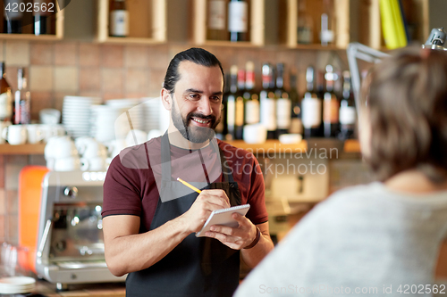 Image of man or waiter serving customer at bar