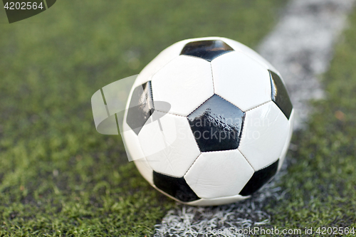 Image of soccer ball on football field marking line