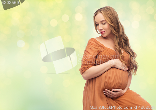 Image of happy pregnant woman touching her big belly