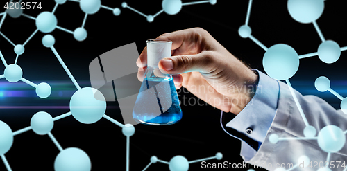 Image of close up of scientist holding flask with chemical