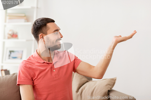 Image of happy man holding something imaginary at home