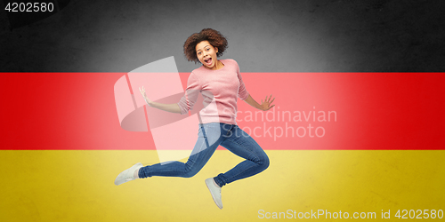 Image of african american woman jumping over german flag