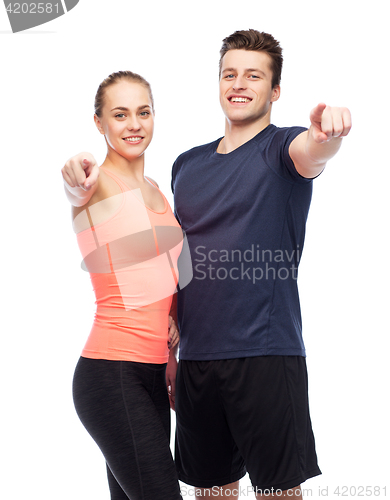 Image of happy sportive man and woman pointing finger