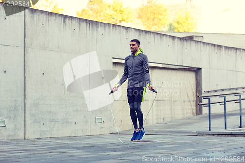 Image of man exercising with jump-rope outdoors