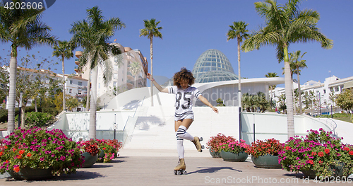 Image of Female wearing rollerskates riding in park