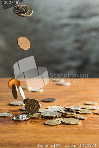 Image of The silver and golden coins and falling coins on wooden background