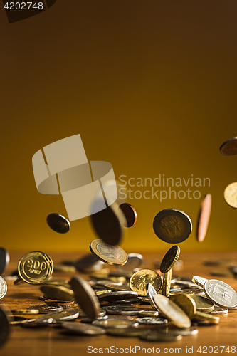 Image of The silver and golden coins and falling coins on wooden background